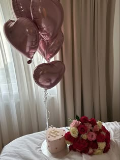 a cake and some balloons on a table with curtains in the backgrounge