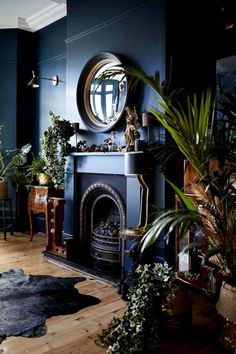 a living room filled with furniture and a fire place under a round mirror on the wall