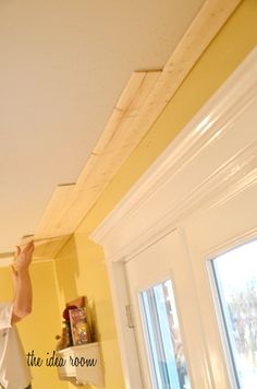 a man is painting the ceiling in his kitchen