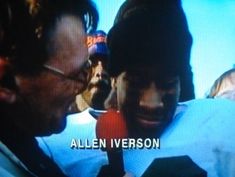 two men are talking to each other in front of a television screen with the words allen iverson on it