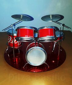 a red drum set sitting on top of a wooden table