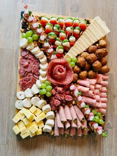 an assortment of meats and cheeses on a board