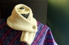 a sweater with a button on the collar and a knitted scarf around it's neck