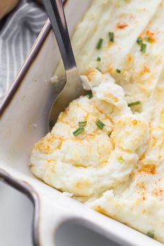 mashed potatoes in a casserole dish with a spoon sticking out of it