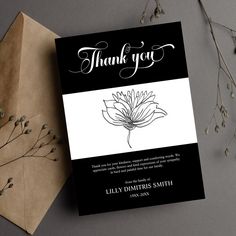 a black and white thank you card with a flower on it next to an envelope