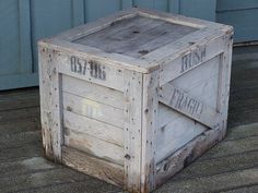 a wooden crate sitting on top of a hard wood floor next to a blue wall