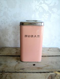 a pink sugar jar sitting on top of a wooden table