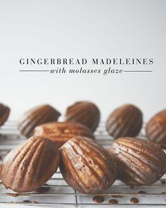 there are many small pastries sitting on the cooling rack with text that reads gingerbread madeleines with molassss glaze