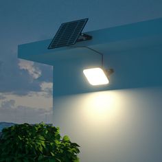 a light that is on the side of a building with a solar panel attached to it