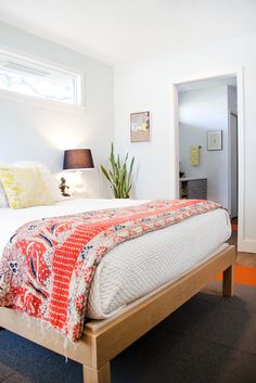 a bedroom with a neatly made bed and two lamps