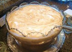 a pie sitting on top of a silver plate next to a knife and glass bowl