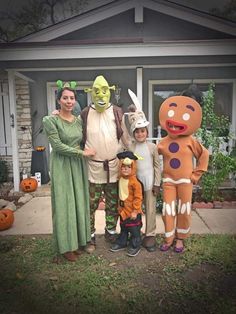 some people are standing in front of a house with costumes on and one person is wearing a costume