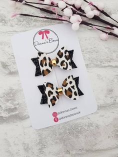 the leopard print bow clip is on top of a card