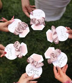 several people holding up small cards with writing on them and bows in the middle one