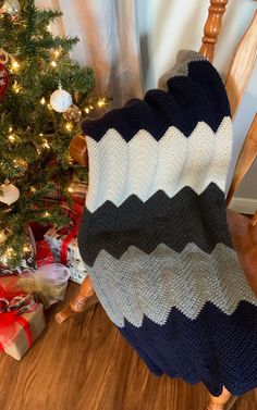 a blanket sitting on top of a wooden chair next to a christmas tree