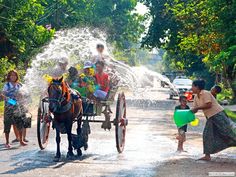 children are playing with water from a horse drawn carriage