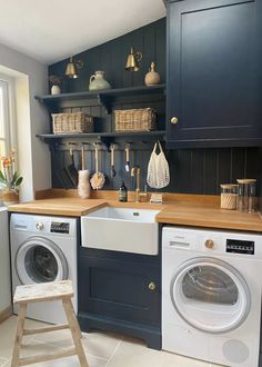 a washer and dryer in a small room with shelves on the wall behind them