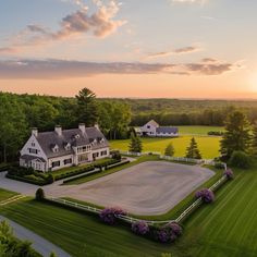 an aerial view of a large white house in the middle of a lush green field