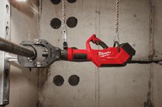 a red and black tool is hanging on the wall