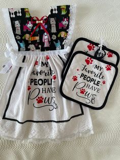 two bibs with sayings on them sitting next to each other in front of a white quilt