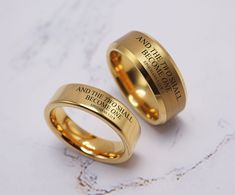 two gold wedding rings sitting on top of each other