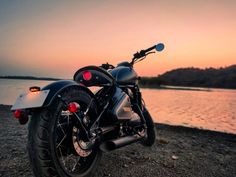 a motorcycle parked on the beach at sunset