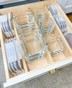 an open drawer filled with glass dishes