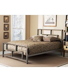 a metal bed frame in a bedroom with beige walls and carpeted flooring next to a window