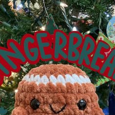 a close up of a stuffed animal in front of a christmas tree with the words gingerbread on it