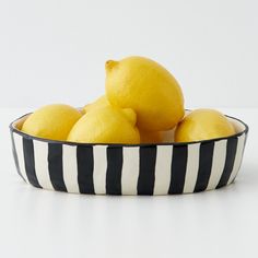 a bowl filled with lemons sitting on top of a table