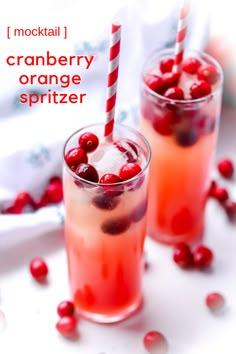 two glasses filled with cranberry orange spritzer next to candy canes