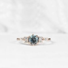 a blue diamond ring with three diamonds around it