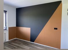 an empty room with wood flooring and painted walls in different colors on the wall