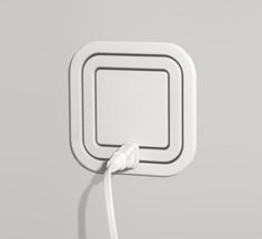 an electronic device is plugged in to the wall with a white cord that runs through it