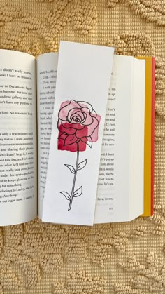 an open book with a rose drawn on it