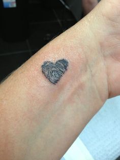 a person with a fingerprint in the shape of a heart on their arm and wrist