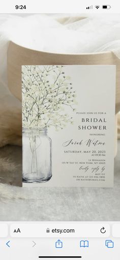 a white wedding card with flowers in a mason jar