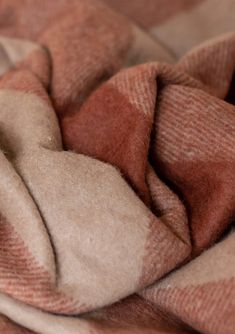 an orange and white checkered blanket laying on top of a bed