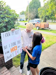 two young people standing next to each other holding signs that say i know my not