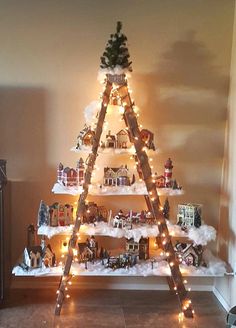 a christmas tree made out of wooden ladders with lights on it and decorations around the top