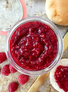 raspberry sauce in a glass jar next to rolls