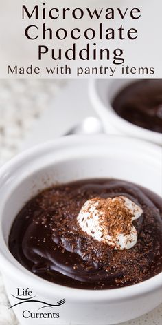 two white bowls filled with chocolate pudding and topped with whipped cream