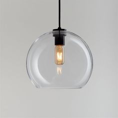 a clear glass pendant light hanging from a black cord