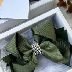 a green bow tie in a white box