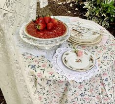 strawberries are sitting on top of a table with plates and napkins around it