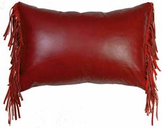 a red leather pillow with fringes on it