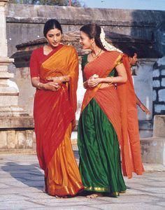 two women standing next to each other in colorful sari