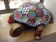 a turtle statue sitting on top of a counter next to a window