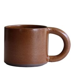 a brown coffee mug sitting on top of a white table