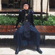 a woman sitting on top of a wooden bench